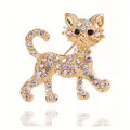 Leuke goudkleurige kattenbroche met sprankelende strass-kristallen als accessoire - Stijl 30 (Lopende gouden kat met witte strass-steentjes en blauwe ogen)