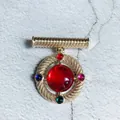 Close-up of a vintage Baroque palace style brooch with a large central red stone - Red Gemstone Vintage Style (2)