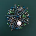 Detailed macro shot of a vintage rhinestone starfish brooch with blue and green gems - Green