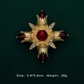 Detailed close-up of a vintage Baroque gold brooch featuring a large red central gemstone. - Relief Ruby Cross Style (5089421201393)
