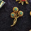 Close-up view of a luxury vintage baroque brooch with colorful rhinestones and gold finish - Triple Flower Gem (09)