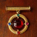 Detailed view of a vintage royal style gold brooch set with vibrant colorful gemstones - Style F Round Twisted (4.8x4cm)