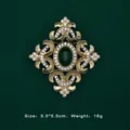 Detailed view of Baroque gold brooch with green gemstone and rhinestones, dimensions shown - Brushed Dark Green Gemstone Style (5089421201398)