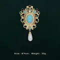 Detailed view of Baroque vintage gold brooch with turquoise and teardrop pearl pendant - Turquoise Purple Rhinestone Style (5089421201400)