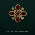 Detail view of Baroque vintage gold brooch with red gemstones and white pearls - Five Ruby Symmetrical Cross Style (5089421201399)