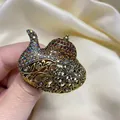 Vue macro d'une broche lampe d'Aladdin exotique avec filigrane doré et strass ambrés - Or antique