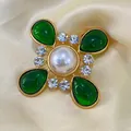 Vue macro d'une broche croix vintage dorée avec gouttes en verre vert et une perle. - Style Perle Verre Vert (Style 3)