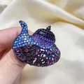 Détail rapproché d'une broche lampe d'Aladin exotique avec des strass colorés vibrants - Argent antique