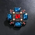 Broche vintage de estilo occidental con cristales coloridos y perlas sobre fondo oscuro - Azul Pavo Real