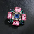 Broche vintage de cristal de colores con gemas rosas y azules sobre fondo negro - Rosa
