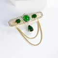 Detailed macro view of vintage British style brooch with emerald green stones and golden chains - Long Medal Style