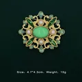 Detailed view of a vintage baroque gold brooch featuring green gemstones and pearls - Emerald Pearl Teardrop Style (5089421201403)