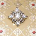 Detail van een barokke vintage kruisbroche met witte parels en glanzende strass-steentjes - Stijl 18 (Antiek Goud Helder Strass Kruis)