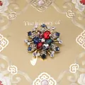 Detailopname van barokke vintage kruisbroche met gekleurde strass-steentjes - Stijl 23 (Antiek Goud Radiale Kleurrijke Edelsteen)