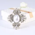 Gedetailleerde weergave van een barokke broche met grote parel en strass steentjes - Stijl 5 (Grote Ovale Parel Kruis)