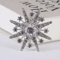 Macrodetail van een sterrenspeld met fonkelende strassteentjes op een witte achtergrond - Stijl 10 (Zilveren Zonnestraal Ster Broche)