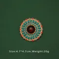 Vue détaillée d'une broche baroque vintage avec pierre rouge centrale et perles - Style Pierre Rouge Ronde (C1-4-8161)