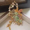 Gros plan d'une broche fée médiévale vintage avec perles irisées et détails dorés - Fée au Bâton Ailée (Style 14)