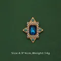 Gros plan d'une broche de style baroque avec pierre bleue, perles et finition dorée. - Style Pierre Bleue (L2-3-2836)