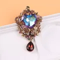 Gros plan d'une broche cœur vintage avec pierre irisée et pendentif en forme de goutte. - Cœur Pierre Fantôme Or Antique (H8-1-2750)