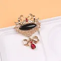 Vue détaillée d'une broche de style vintage avec une pierre noire et des cristaux rouges - Style Nœud avec Pierre Noire Ovale (D5-1-7211)