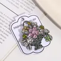 Detailed macro view of a vintage style flower basket brooch with colorful rhinestones on a card - Antique Silver Color Rhinestone Basket Style