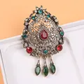 Détail d'une broche de cour vintage luxueuse avec des gemmes colorées et des pendentifs larmes. - Style Palais Goutte de Pierre Rouge (A3-6-276)