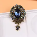 Détail d'une broche de style royal vintage avec un grand cristal bleu et des strass - Pierre Bleu Foncé Floral Or Antique (H3-3-2321)