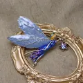 Dettaglio macro di una spilla fata vintage con ali blu scintillanti su cornice dorata - Fata Sfumata Blu (Stile 1)