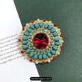 Vintage barokke goudkleurige broche met een rode edelsteen en turquoise stenen - Gemstone Sun Round