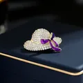 Elegant hat-shaped brooch with sparkling crystals and a purple enamel ribbon detail. - Gold Purple Ribbon Hat