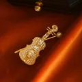 Elegant vintage gold-tone violin brooch encrusted with cubic zirconia and a pearl detail - Violin Brooch (AL736793235791) / White