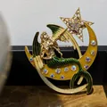 Gedetailleerde weergave van een vintage zeemeerminbroche met kristallen maan en ster. - Maan Zeemeermin Fee