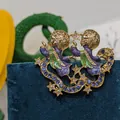Vintage goldfarbene Engelsbrosche mit lila Emaille und blauen Kristallen - Zwillingsengel Sterne