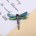 Detailed macro shot of vintage dragonfly brooch with colorful abalone shell inlays - Blue-Green Iridescent Style