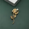 Macro detail of elegant golden rose brooch with white pearl accent in vintage style - Vintage Brushed Rose Flower Style