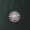 Detailed view of an elegant vintage Baroque pearl brooch on green velvet background - Double Row Rhinestone Pearl Cross Style