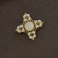 Detailopname van een vintage barokke gouden kruisbroche met parels en steen - Barokke vintage kruisstijl