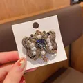 Primer plano de broche de mariposa vintage con cristales brillantes y perlas finas - Broche de Lazo / Azul