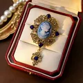 Close-up of a vintage cameo brooch with blue relief and rhinestones inside a red box - Lady Portrait Cameo (Blue) / Blue
