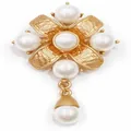 Exquisite close-up of a vintage baroque gold floral brooch adorned with elegant white pearls - V09