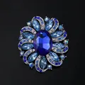 Vintage blue rhinestone flower brooch with elegant oval centerpiece in silver-toned alloy - Blue