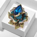 Close-up of luxury flower brooch with large blue teardrop crystal and pavé settings - Blue