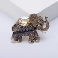 Detailed close-up of vintage elephant brooch with sparkling purple and gold rhinestones - Coffee