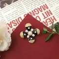 Vintage Baroque cross brooch with black enamel and pearl inlays on a classic red background - Black Pearl Cross