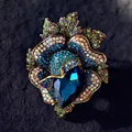Luxurious vintage flower brooch featuring vibrant blue and green crystals and teardrop gem - Blue