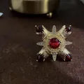 Detailansicht einer antiken goldenen Barock-Kreuzbrosche mit roten Edelsteinen. - Großer Roter Rubin Stil Kreuz