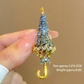 Detailed macro shot of vintage gold umbrella brooch featuring blue and clear rhinestones - Antique Gold Umbrella