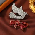 Primo piano dettagliato di una spilla a uccello vintage con cristalli e nastro rosso - Spilla Uccello della Fortuna con Fiocco
