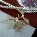 Detailed close-up of a vintage matte gold branch brooch with three elegant white pearls - Frosted Gold Leaf Branch (SMT1005004046954097)